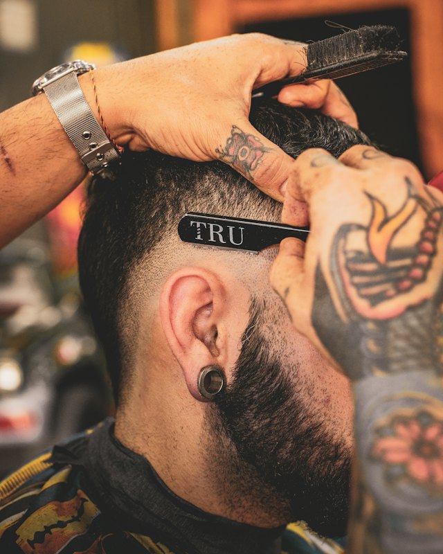 Barbeiro finalizando um corte